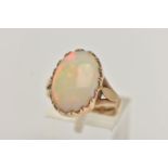 A 9CT GOLD OPAL RING, large oval opal cabochon, showing flashes of all the colours in the