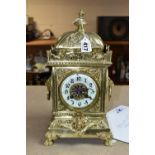 A 20TH CENTURY BRASS MANTEL CLOCK, the heavily cast case with urn shaped finial on domed top, the