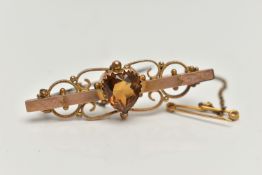 A YELLOW METAL SWEETHEART BROOCH, set with a central heart cut citrine, to a polished bar with