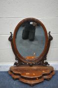 A VICTORIAN FLAME MAHOGANY OVAL BEVELLED EDGE SWING TOILET MIRROR, with foliate details, with a