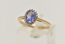 A 9CT GOLD GEM CLUSTER RING, designed as a central oval tanzanite within a circular cut colourless