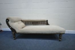 A 20TH CENTURY OAK CHAISE LONGUE, the back with spindle supports and foliate central design, beige