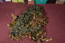 A LARGE VEHICLE CAMOUFLAGE NET, it is a mix of light and dark green plus brown to imitate leaves