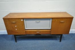 A MID-CENTURY TEAK SIDEBOARD, with cupboard doors flanking a fall front door over a single drawer,