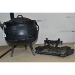 A CAST IRON THREE LEGGED CAULDRON WITH LID AND SWING HANDLE, TOGETHER WITH A WORN VICTORIAN CAST