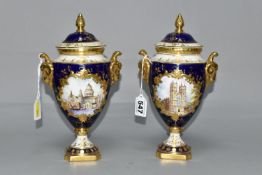TWO COALPORT TWIN HANDLED VASES AND COVERS, blue, gilt and pale yellow ground, one with a hand