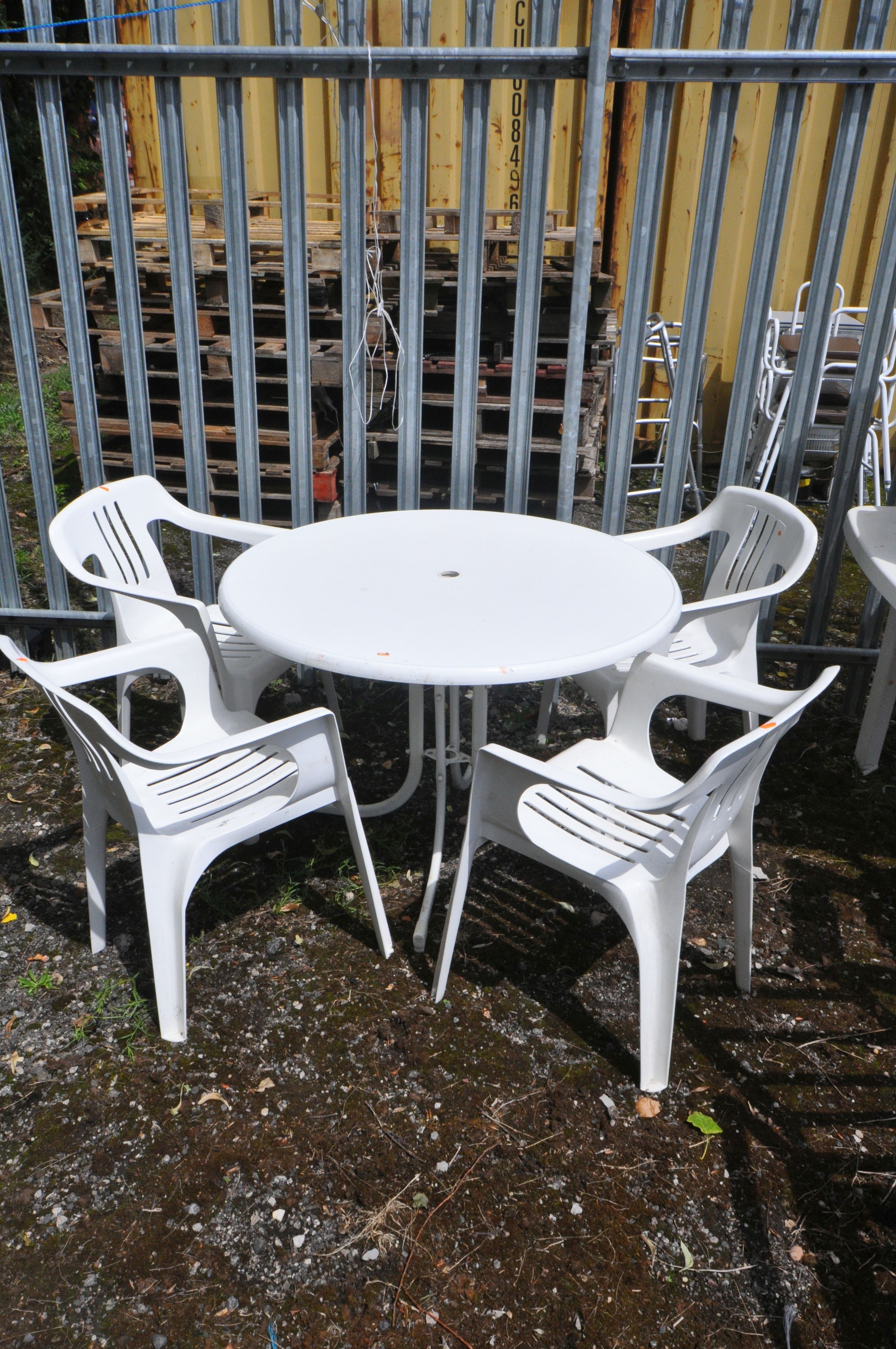 A PLASTIC CIRCULAR GARDEN TABLE, diameter 102cm x height 71cm and four armchairs (5)