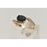 A 9CT GOLD SAPPHIRE AND DIAMOND RING, centring on an oval cut deep blue sapphire, within single