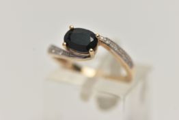 A 9CT GOLD SAPPHIRE AND DIAMOND RING, centring on an oval cut deep blue sapphire, within single