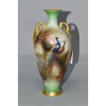 A ROYAL WORCESTER HADLEY SHAPE TWIN HANDLED BALUSTER VASE, hand painted with a peacock and peahen
