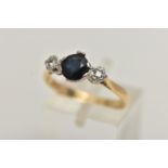 AN 18CT GOLD SAPPHIRE AND DIAMOND RING, a circular cut blue sapphire, set with two illusion set