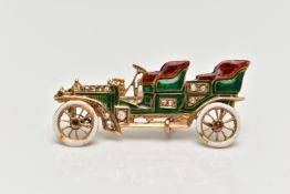 AN EARLY 20TH CENTURY GOLD CAR BROOCH, yellow gold brooch with red, green and white enamel detail,