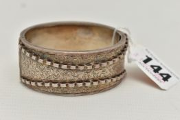 A LATE VICTORIAN SILVER HINGED BANGLE, engraved ivy leaf detail, with a raised scallop pattern,