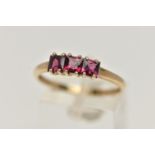 A 9CT GOLD THREE STONE RING, three square cut garnets, each claw set, to a polished yellow gold