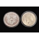 TWO SILVER UNITED STATES OF AMERICA ONE DOLLAR COINS, each in a protective capsule, 1922 and 1929