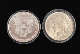 TWO SILVER UNITED STATES OF AMERICA ONE DOLLAR COINS, each in a protective capsule, 1922 and 1929