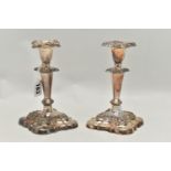 A PAIR OF SILVER PLATE CANDLE STICKS, silver on copper candle sticks, weighted square bases, with