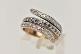 A 9CT GOLD DIAMOND RING, cross over design with a central row of treated blue diamonds, between