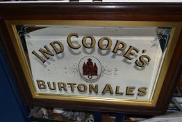 A LARGE DARK OAK FRAMED PUB ADVERTISING MIRROR, 'Ind Coope's Burton Ales' with a central red logo,