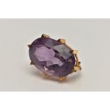 A YELLOW METAL AMETHYST BROOCH, large oval cut amethyst in an eight claw setting, amethyst measuring