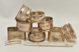 EIGHT SILVER NAPKIN RINGS AND A TEA FORK, eight napkin rings of various styles, all with a full