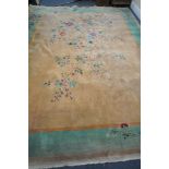 A LARGE 20TH CENTURY CHINESE WOOLLEN RUG, with a central flowering tree, and a green border, 360cm x