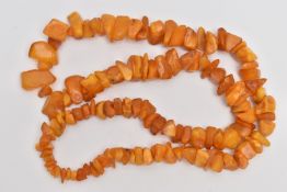 AN AMBER BEAD NECKLACE, graduating rough pieces of natural amber, length 680mm, approximate gross