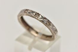 A WHITE METAL AND DIAMOND ETERNITY BAND RING, a flat profile band with a diamond cut pattern to