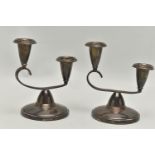 A PAIR OF ELKINGTON & CO SILVER CANDLE STICKS, each on a round weighted base, with scroll detail set