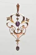 AN EARLY 20TH CENTURY LAVALIER PENDANT, an open work scrolling pendant, set with two seed pearls and