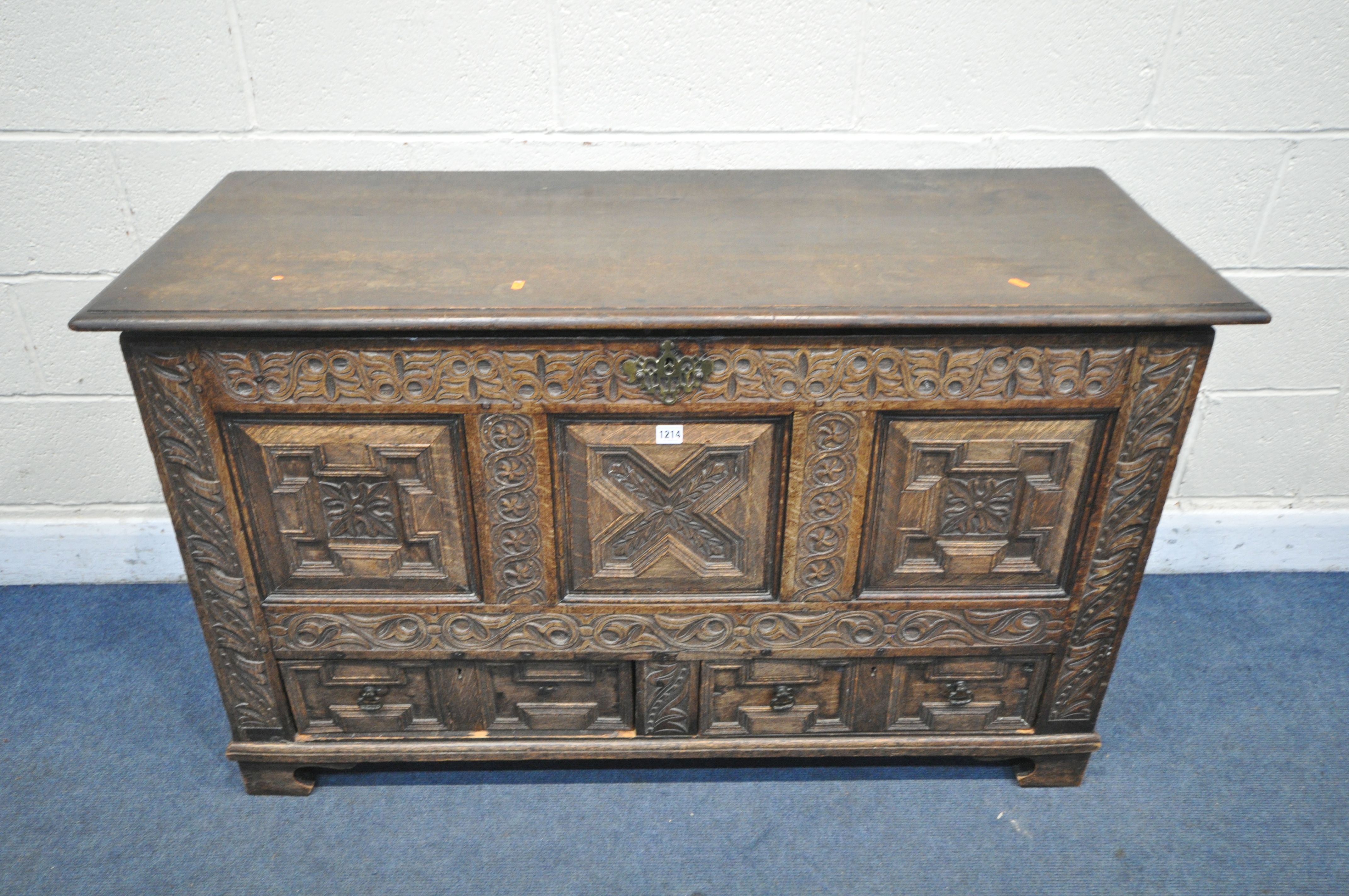 A GEORGIAN AND LATER CARVED OAK PANELLED MULE CHEST, the front with geometric panels, foliate