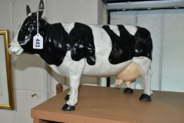 A LARGE CAST METAL FREISIAN COW MONEY BOX, with stopper, height 29cm x length 43cm (1) (Condition