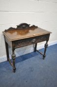 AN EARLY 20TH CENTURY CARVED OAK SIDE TABLE, with mask detail, raised back and a single drawer,