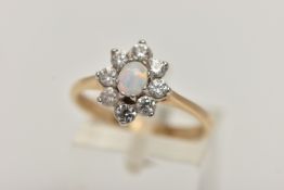 A 9CT GOLD OPAL RING, oval cabochon opal prong set with a cluster of eight circular cut cubic