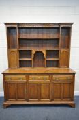 AN EARLY 20TH CENTURY OAK DRESSER, the top with an arrangement of shelving, and cupboard doors, over
