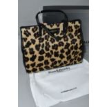 A NEW AND UNUSED RUSSELL & BROMLEY HANDBAG, faux leopard print with dust bag, original shoulder