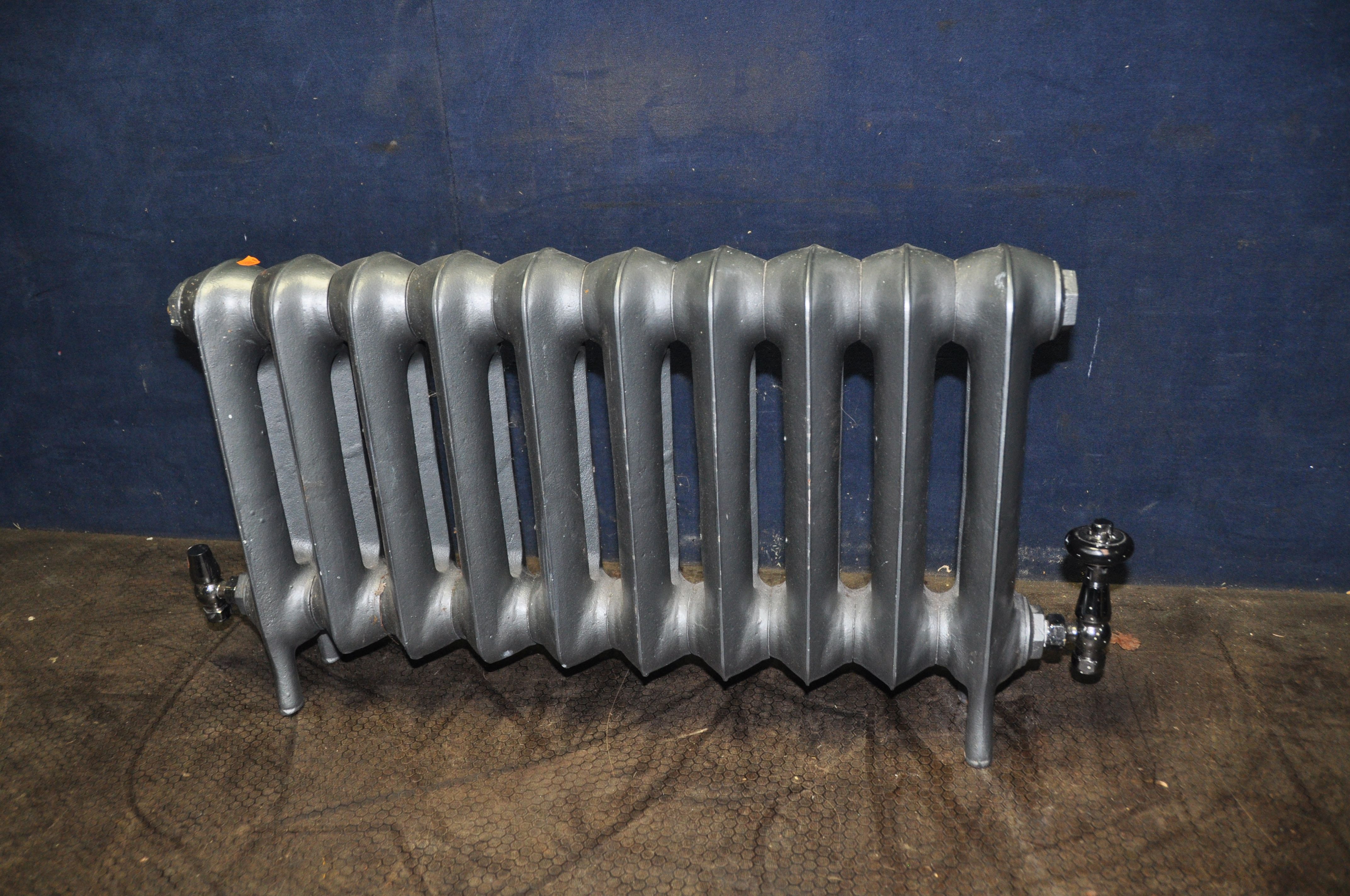 A MODERN CAST IRON RADIATOR with black chromed fittings, width 90cm x depth 13cm x height 45cm (