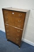 A TALL MID-CENTURY G PLAN TOLA AND BLACK AFROMOSIA TEAK CHEST OF SEVEN DRAWERS, on ebonised legs,