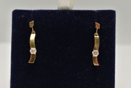 A PAIR OF 18CT GOLD DIAMOND DROP EARRINGS, each of a polished curved bar set with a round
