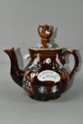 A BARGEWARE TEAPOT, having brown treacle glaze, sprigged peacock and floral decoration, plaque