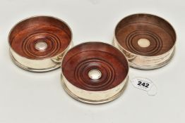 THREE ELIZABETH II SILVER BOTTLE COASTERS, with turned wooden inset bases, green baize to bases,