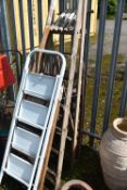 FOUR SETS OF STEP LADDERS, to include an aluminium ladder, and three sized wooden ladders, tallest