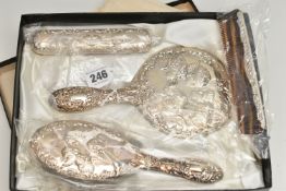 A BOXED ELIZABETH II SILVER MOUNTED FOUR PIECE DRESSING TABLE SET, repoussé decorated with
