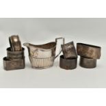 A LATE VICTORIAN SILVER CREAM JUG AND SEVEN ASSORTED SILVER NAPKIN RINGS, the oval cream jug with