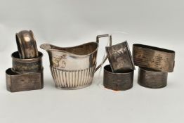 A LATE VICTORIAN SILVER CREAM JUG AND SEVEN ASSORTED SILVER NAPKIN RINGS, the oval cream jug with
