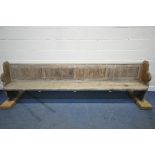 A LONG 19TH CENTURY PINE CHURCH PEW, length no including later raised bases 297cm (condition report: