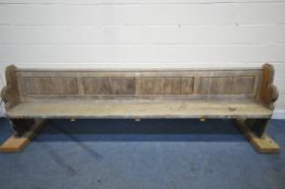 A LONG 19TH CENTURY PINE CHURCH PEW, length no including later raised bases 297cm (condition report:
