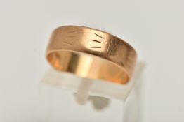 A YELLOW METAL WIDE BAND RING, approximate band width 5.5mm, worn textured engraved pattern, stamped