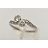A WHITE METAL DIAMOND CROSS OVER RING, set with two round brilliant cut diamonds, each claw set,