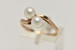 A CULTURED PEARL RING, two cultured pearls set in a yellow metal bypass mount, unmarked, ring size N